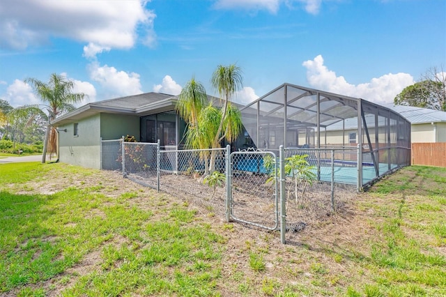 exterior space with glass enclosure and a lawn