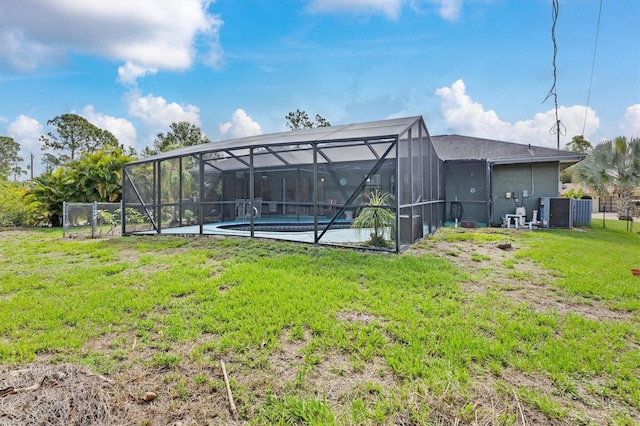 back of property with a yard and glass enclosure