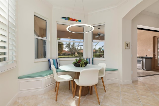 dining area featuring ceiling fan, light tile patterned flooring, and ornamental molding