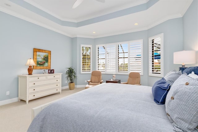 bedroom with a tray ceiling, ceiling fan, light carpet, and ornamental molding