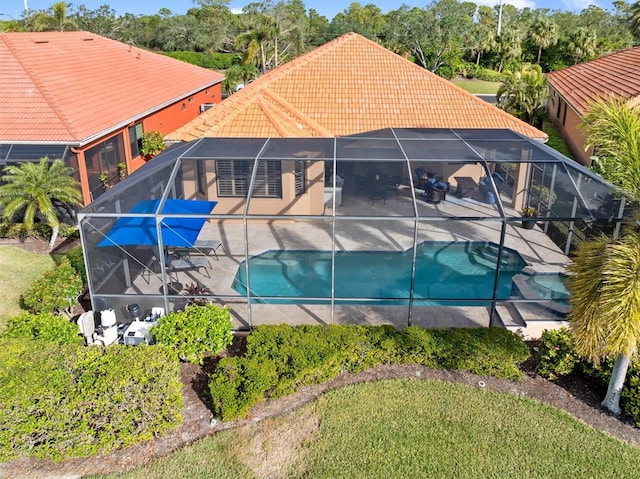 view of swimming pool with glass enclosure and a patio