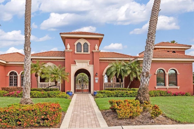 mediterranean / spanish-style home featuring a porch and a front lawn