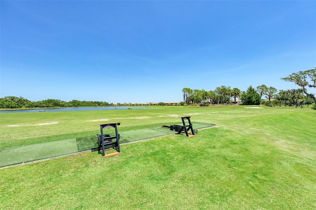 surrounding community with a water view and a lawn