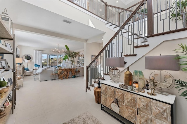 stairs with tile patterned flooring and an inviting chandelier