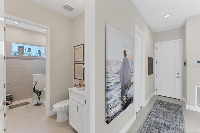 bathroom with tile patterned floors, walk in shower, vanity, and toilet