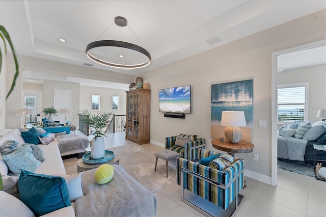 living room with a raised ceiling and light tile patterned flooring