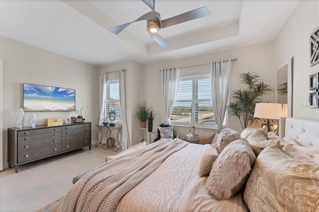 bedroom featuring a tray ceiling, ceiling fan, and light tile patterned floors