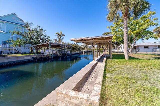 dock area with a lawn and a water view