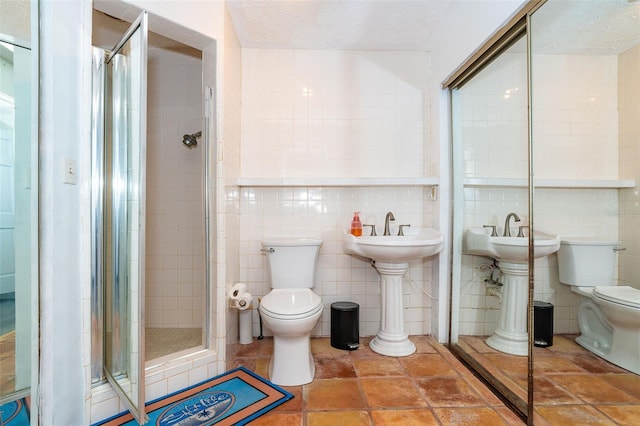 bathroom with an enclosed shower, toilet, tile walls, and a textured ceiling