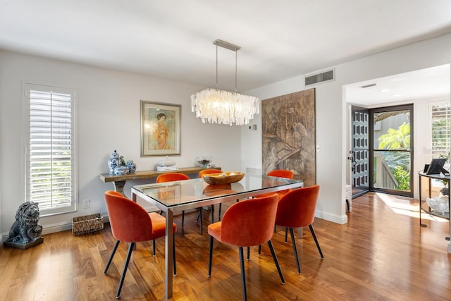 dining area with a chandelier and light hardwood / wood-style flooring