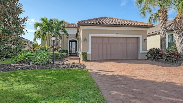 mediterranean / spanish house featuring a garage and a front lawn