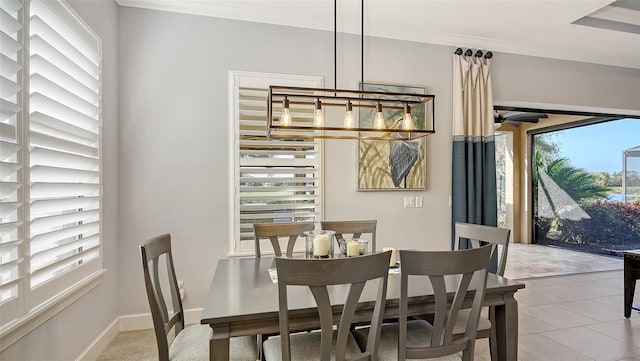 dining area featuring light tile patterned floors, crown molding, and a notable chandelier