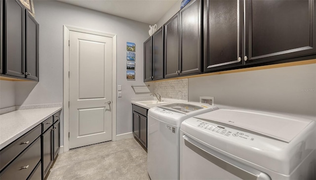 clothes washing area with cabinets, separate washer and dryer, and sink