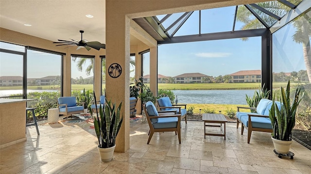 sunroom / solarium featuring ceiling fan, plenty of natural light, and a water view