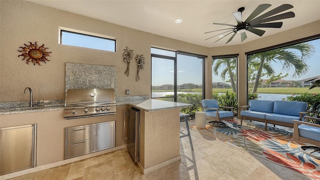 interior space with outdoor lounge area, sink, ceiling fan, a grill, and exterior kitchen