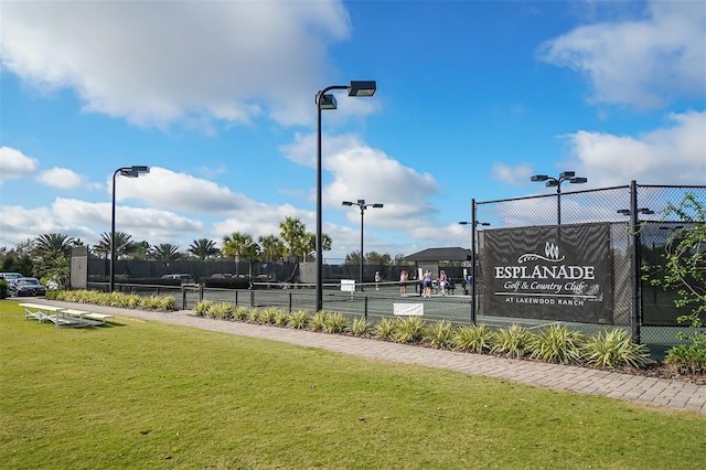 view of sport court with a lawn