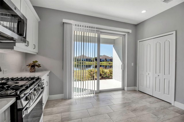 kitchen featuring a water view, white cabinetry, and stainless steel appliances