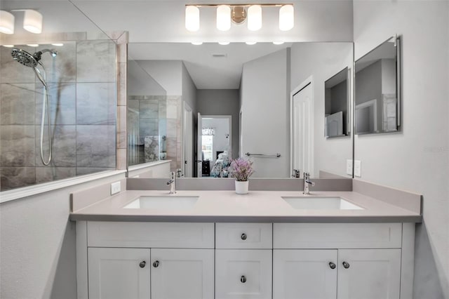 bathroom featuring a shower with door and vanity