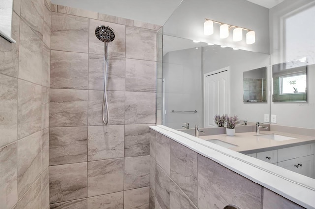 bathroom featuring a tile shower and vanity