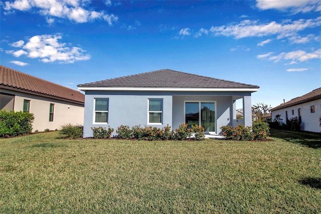 rear view of property featuring a lawn