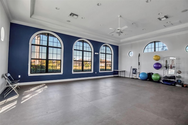 workout room featuring ceiling fan, a raised ceiling, ornamental molding, and a wealth of natural light