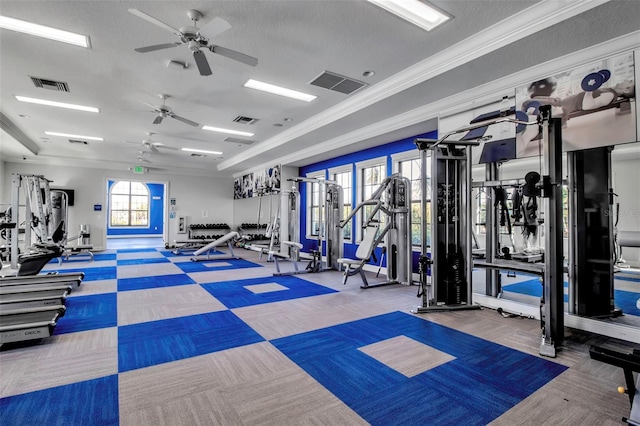 workout area featuring ceiling fan, carpet, a textured ceiling, and ornamental molding