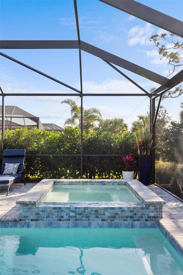 view of swimming pool featuring an in ground hot tub, a lanai, and a patio area