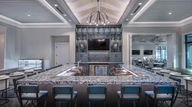 kitchen featuring a kitchen breakfast bar, an inviting chandelier, pendant lighting, and high vaulted ceiling