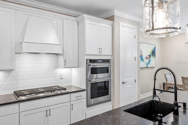 kitchen with white cabinets, appliances with stainless steel finishes, custom range hood, sink, and crown molding