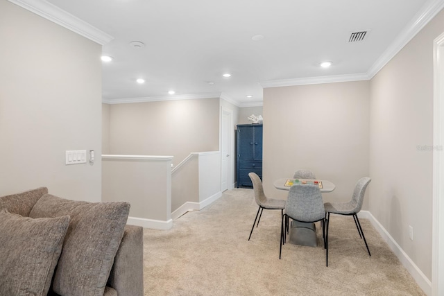 dining space featuring crown molding and light carpet