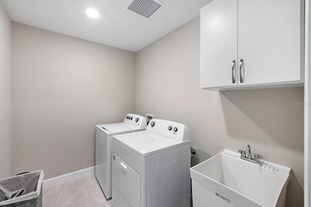 laundry room with washing machine and dryer, light tile patterned flooring, sink, and cabinets