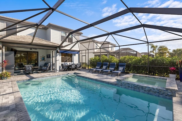 view of pool featuring a lanai, a patio area, and an in ground hot tub