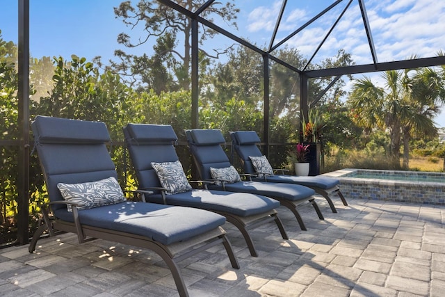 view of patio / terrace featuring glass enclosure and an in ground hot tub