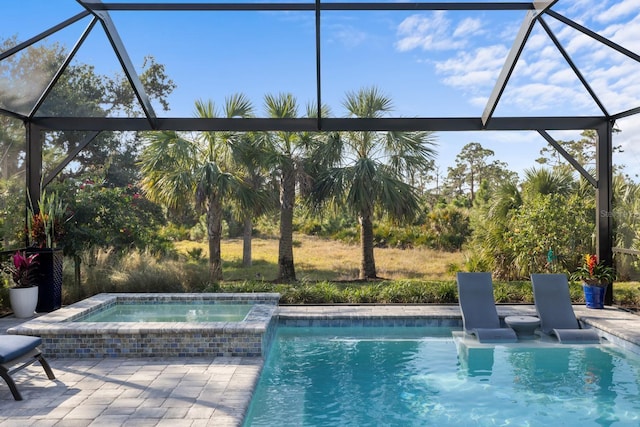 view of pool featuring a lanai, an in ground hot tub, and a patio