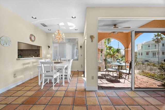 interior space featuring ceiling fan with notable chandelier and tile patterned floors