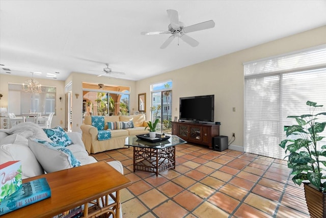 tiled living room featuring ceiling fan with notable chandelier