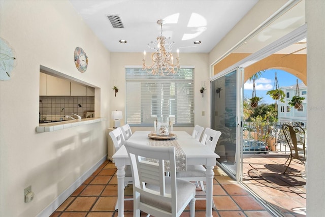 dining area featuring light tile patterned flooring, a chandelier, and a wealth of natural light