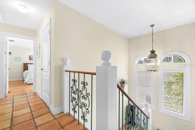 hallway featuring light tile patterned flooring and a chandelier