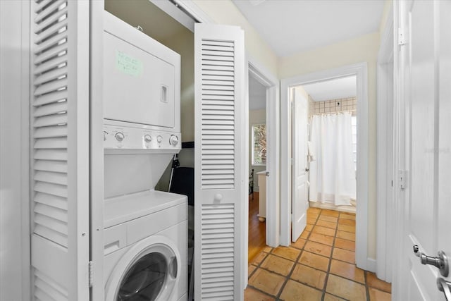 clothes washing area with stacked washing maching and dryer and light tile patterned floors