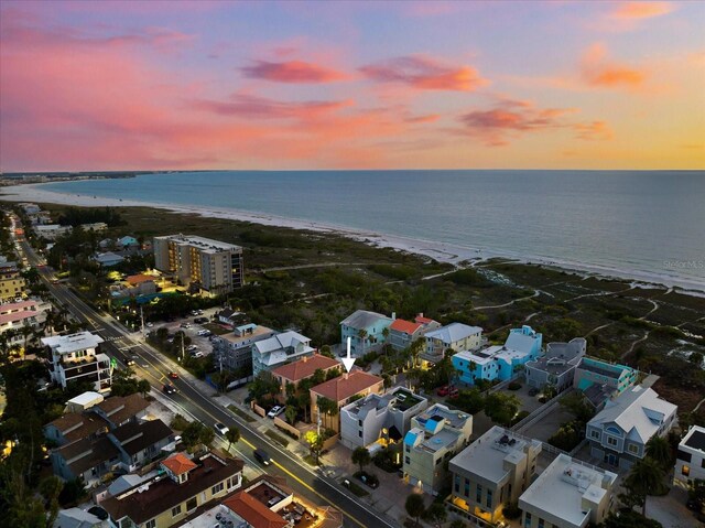 aerial view at dusk with a beach view and a water view