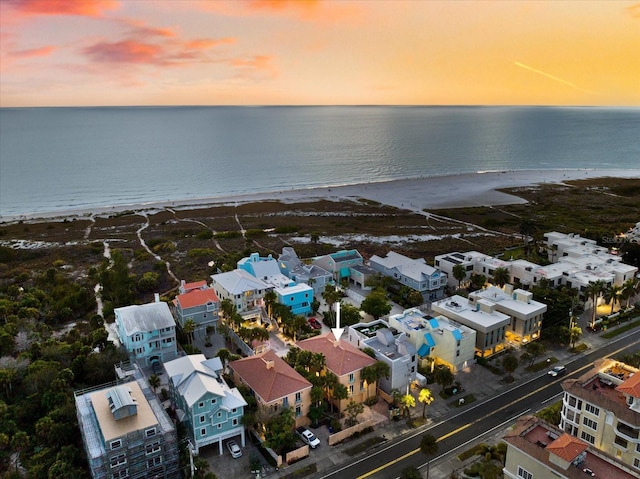 aerial view at dusk with a view of the beach and a water view