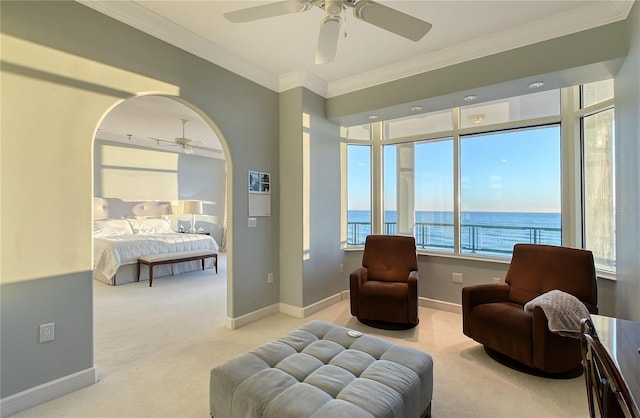 living area featuring a water view, ceiling fan, crown molding, and light carpet