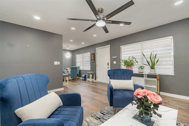 living room featuring ceiling fan and light wood-type flooring