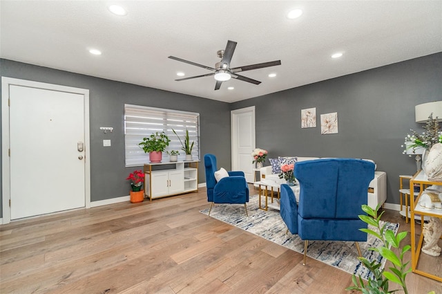 living area featuring a textured ceiling, ceiling fan, and light hardwood / wood-style flooring