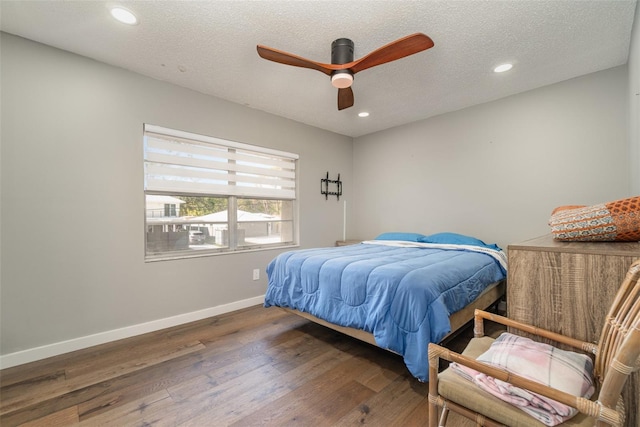 bedroom featuring dark wood-type flooring, ceiling fan, and a textured ceiling