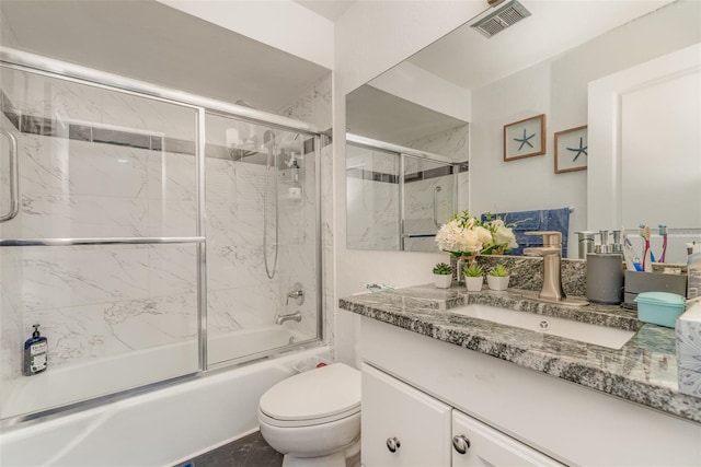 full bathroom featuring vanity, enclosed tub / shower combo, and toilet