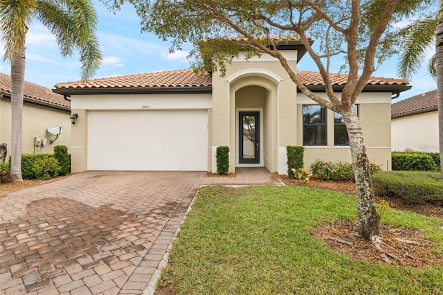 mediterranean / spanish home featuring a front yard and a garage