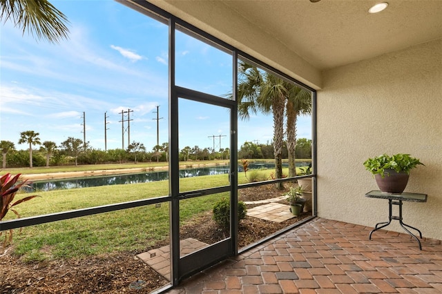 sunroom / solarium featuring a water view