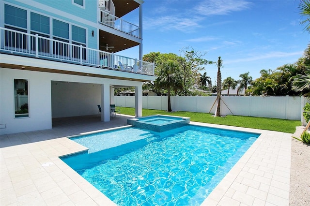 view of pool with an in ground hot tub, ceiling fan, a patio area, and a lawn