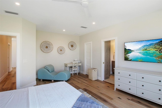 bedroom with ceiling fan, light hardwood / wood-style floors, and ensuite bath